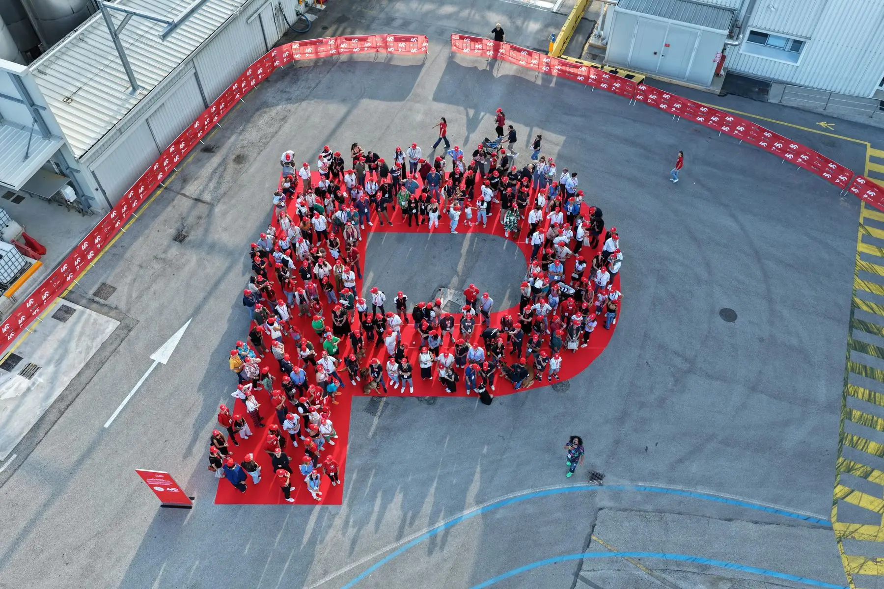 Aerial view of hundreds of people forming a letter