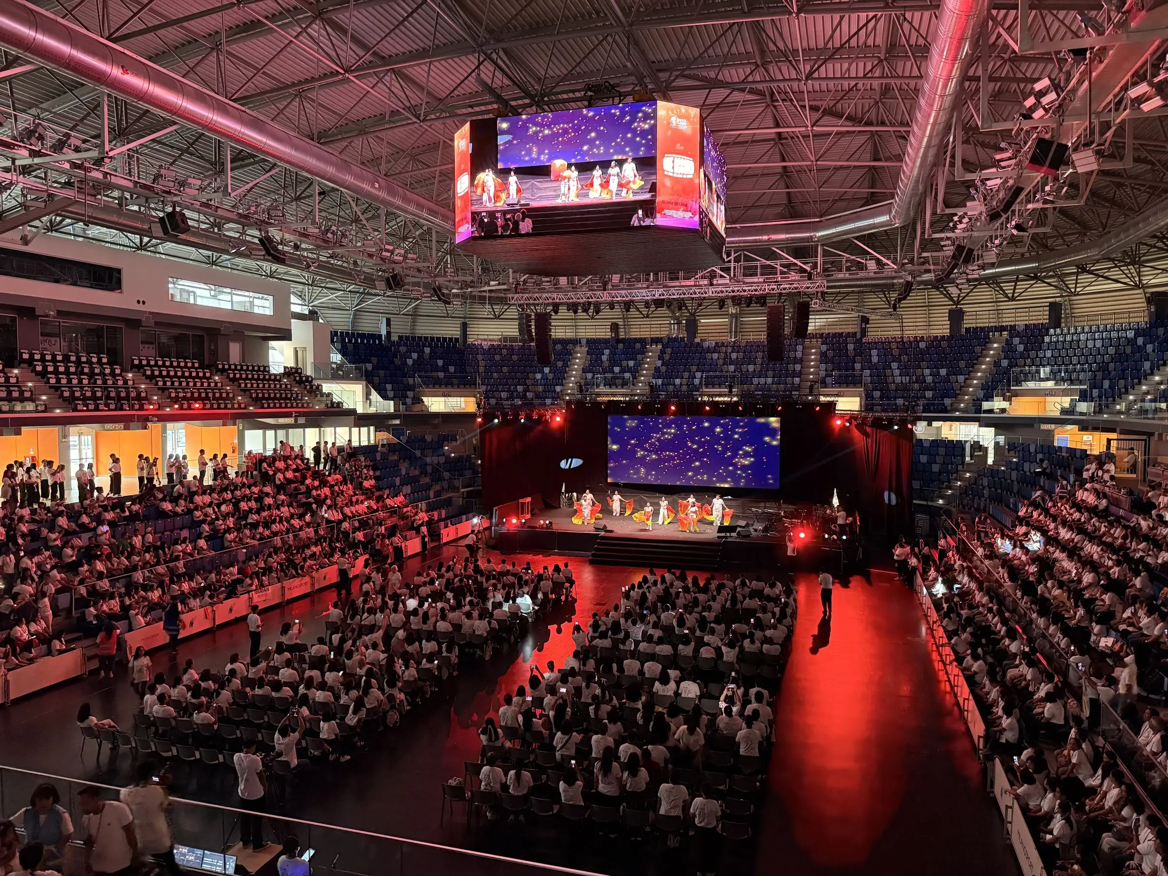 Packed arena with a central giant screen