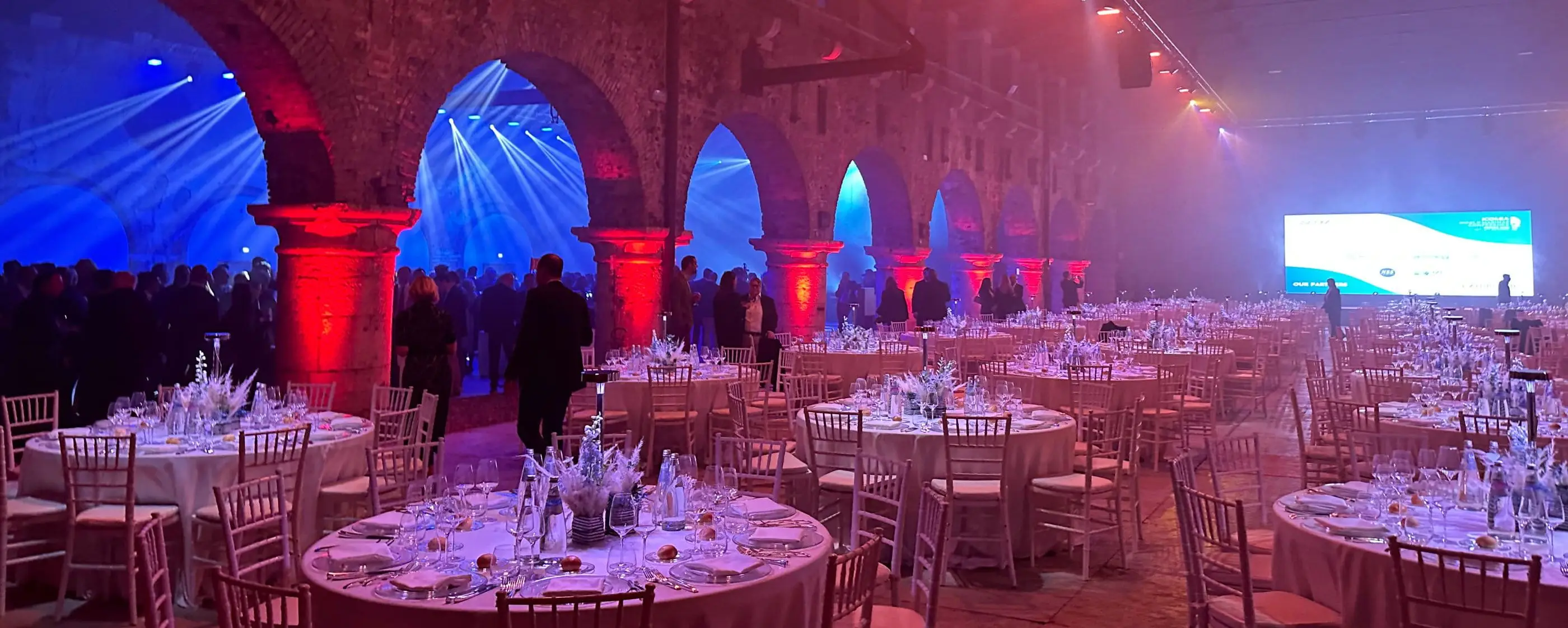 Gala dinner under historic arches with light beams